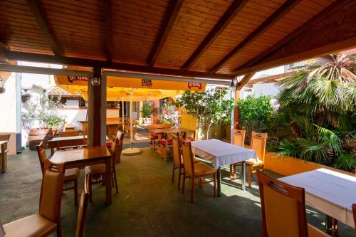ein leeres Restaurant mit Tischen, Stühlen und Sonnenschirmen in der Unterkunft Apartments with parking space Bibinje, Zadar - 18275 in Bibinje