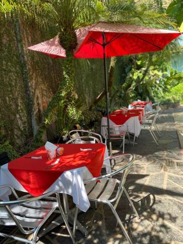 a group of tables and chairs with red umbrellas at Hotel Camino Surreal Xilitla in Xilitla