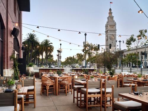 a restaurant with tables and chairs and a clock tower at 1 Hotel San Francisco in San Francisco