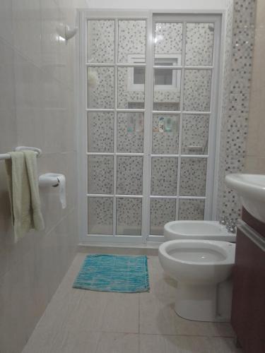 La salle de bains blanche est pourvue de toilettes et d'un lavabo. dans l'établissement Departamento con Balcon - Sin Aire Acondicionado - Con Ventiladores - Serena Alojamientos, à Villa Constitución