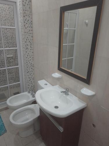 La salle de bains est pourvue d'un lavabo, de toilettes et d'un miroir. dans l'établissement Departamento con Balcon - Sin Aire Acondicionado - Con Ventiladores - Serena Alojamientos, à Villa Constitución
