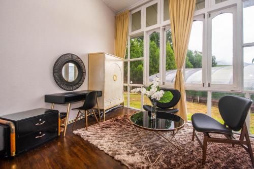 a living room with a table and chairs and a mirror at La Cantane Villa in Kundasang