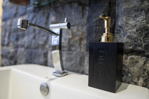 a black soap dispenser sitting on top of a sink at La Cantane Villa in Kundasang