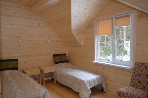 Habitación con 2 camas en una cabaña de madera en Sadyba Lisova Kvitka, en Verkhniy Yasenov