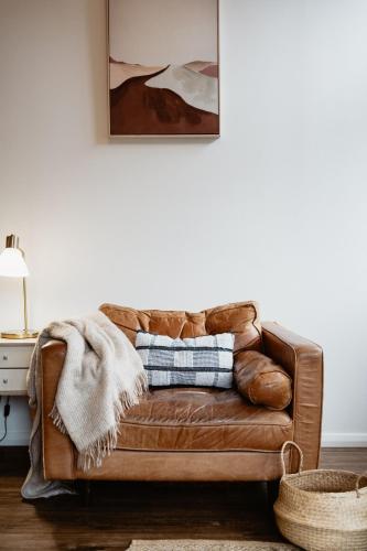 a brown leather couch sitting in a living room at Premalaya in Yallingup
