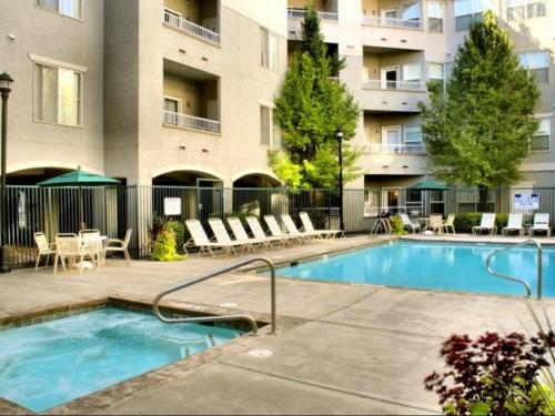 a swimming pool with chairs and a building at 1-Bedroom Condo in the Heart of the City in Salt Lake City