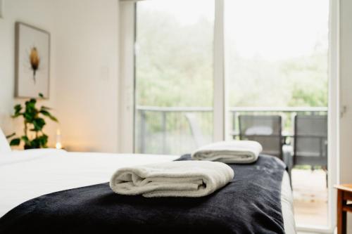 two towels on a bed in a room with a window at Premalaya in Yallingup