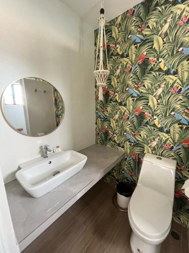 a bathroom with a sink and a mirror and a toilet at Red Knight Gardens in Davao City