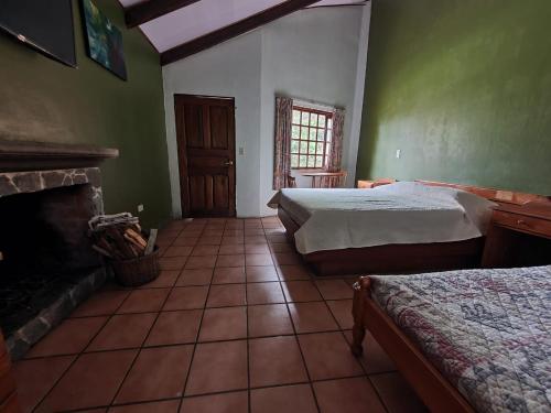 a bedroom with two beds and a fireplace at Hotel Villa Zurqui in San José