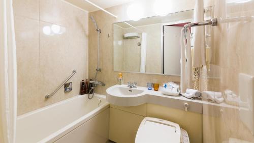 a bathroom with a sink and a toilet and a mirror at JR-East Hotel Mets Shibuya in Tokyo