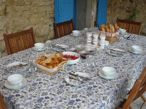 une table avec un chiffon de table bleu et blanc à motifs et de la nourriture dans l'établissement Le Mas Saint Jacques, à Crillon-le-Brave