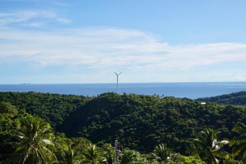 a wind turbine on top of a hill with the ocean at KohTao Studios Sunset in Koh Tao