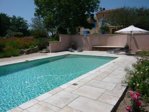 einen Pool in einem Hof mit einem Haus in der Unterkunft Le Mas Saint Jacques in Crillon-le-Brave