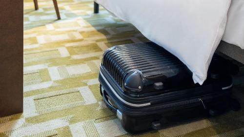 a suitcase sitting next to a bed with a pillow at JR East Hotel Mets Premier Tokyo Bay Shinkiba in Tokyo