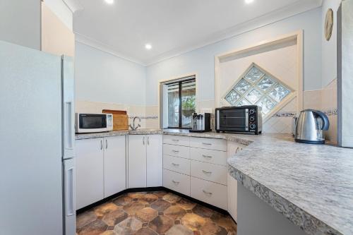 a kitchen with white cabinets and a counter top at Wave Haven in Dalmeny