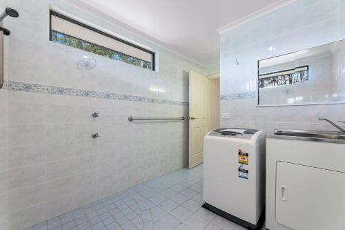 een badkamer met een wastafel en een wasmachine bij Wave Haven in Dalmeny
