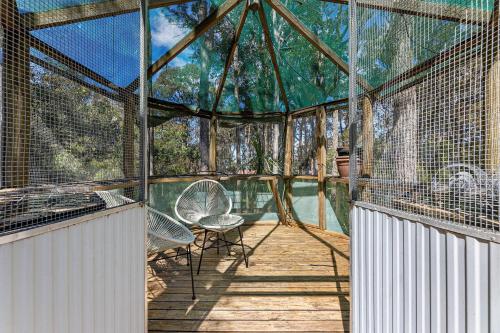 a large cage with a table and chairs on a wooden deck at Wave Haven in Dalmeny