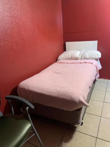 a red room with a bed and a chair at The Ugly House in Houston