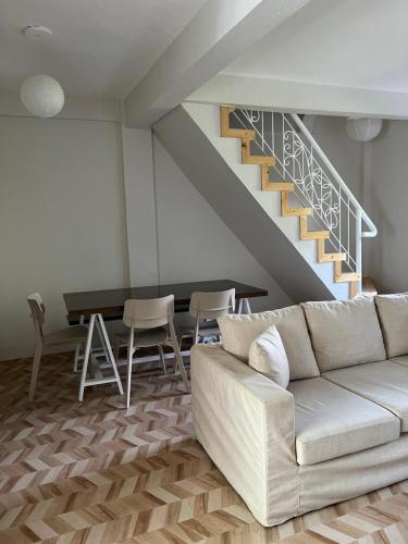 a living room with a couch and a staircase at Red Knight Gardens in Davao City