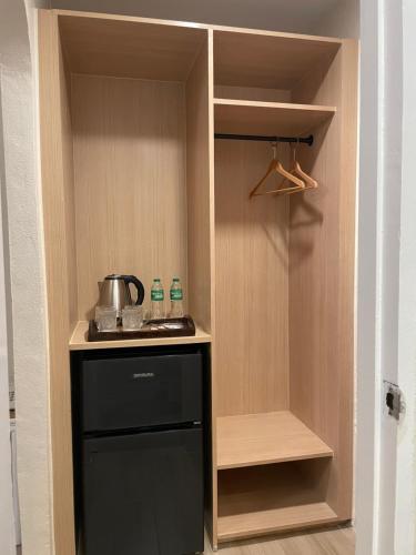 a kitchen with a stove and a black refrigerator at Red Knight Gardens in Davao City