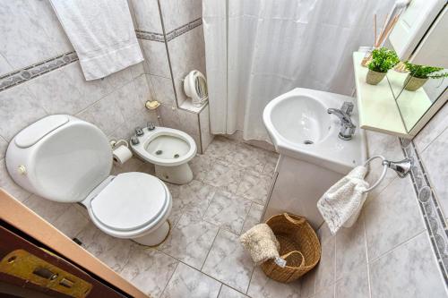 a bathroom with a toilet and a sink at La casa de tigre Centro in Tigre