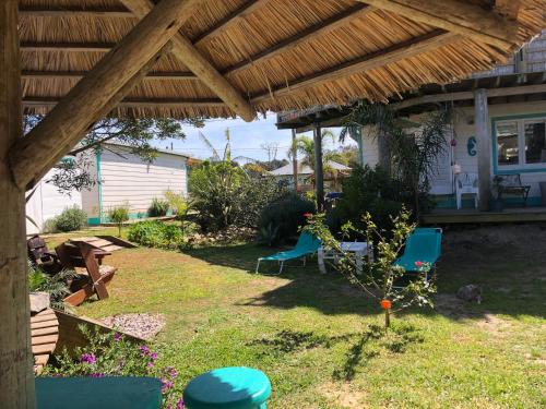 a yard with chairs and a wooden pergola at Posada Agua Marina in La Paloma
