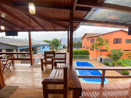 a patio with a table and benches and a pool at Casa hotel in Barra do Guarita