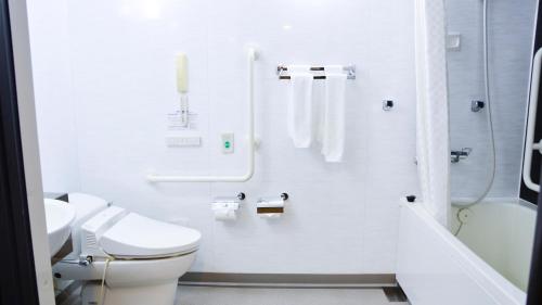 a white bathroom with a toilet and a shower at JR-East Hotel Mets Yokohama Tsurumi in Yokohama