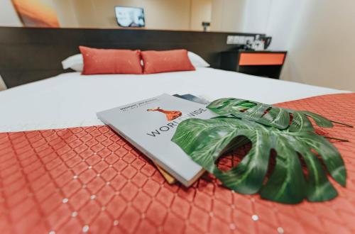 un libro seduto su un letto con un nastro verde di Hotel 81 Heritage a Singapore