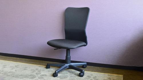 a black office chair sitting against a purple wall at JR-East Hotel Mets Yokohama Tsurumi in Yokohama