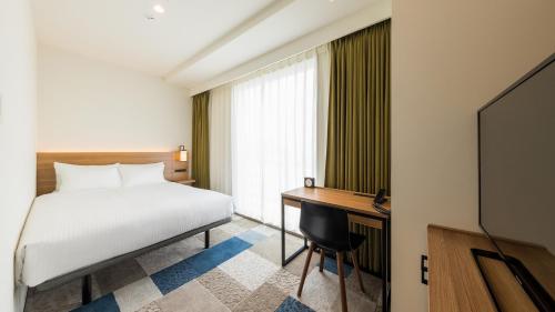 Ένα ή περισσότερα κρεβάτια σε δωμάτιο στο JR-East Hotel Mets Yokohama Sakuragicho