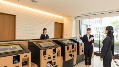 three women standing in a room with boxes at JR East Hotel Mets Premier Yokohama Sakuragicho in Yokohama