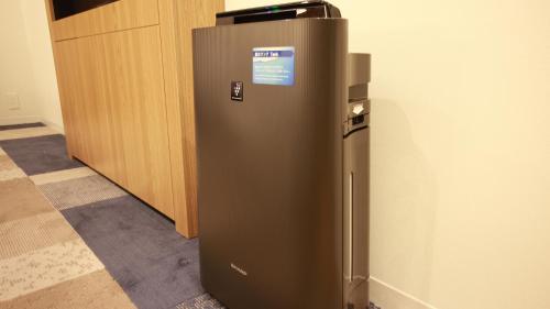 a brown refrigerator in a room with a wall at JR East Hotel Mets Premier Yokohama Sakuragicho in Yokohama