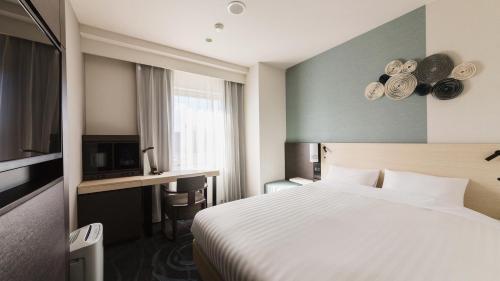 a hotel room with a bed and a television at JR-East Hotel Mets Mizonokuchi in Kawasaki
