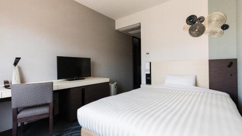 Postel nebo postele na pokoji v ubytování JR-East Hotel Mets Mizonokuchi