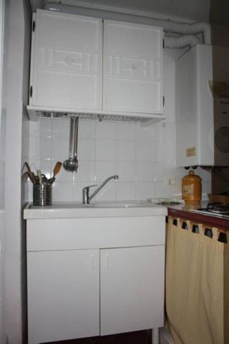 a kitchen with white cabinets and a sink at La Chiave di Volta in Ragusa