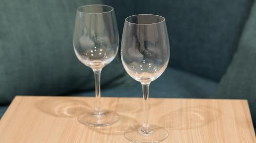two wine glasses sitting on top of a wooden table at JR-East Hotel Mets Mito in Mito