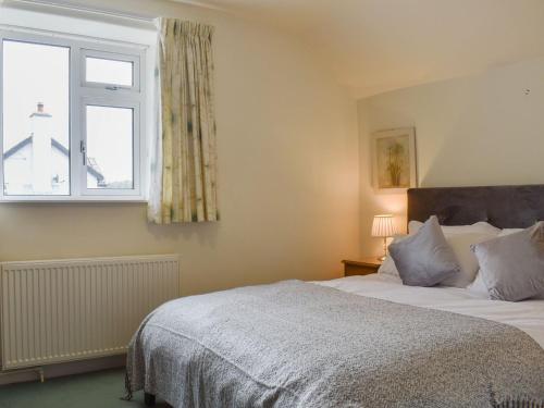 um quarto com uma cama e uma janela em Lupton Hall Cottages em Lupton