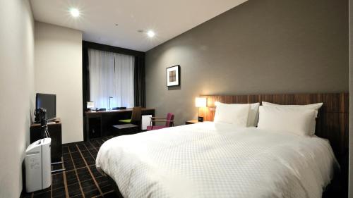 Postel nebo postele na pokoji v ubytování JR-East Hotel Mets Utsunomiya
