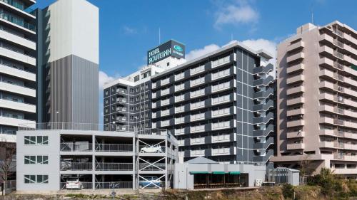 a tall building with a sign on top of it at Hotel Route-Inn Kumamoto Ekimae in Kumamoto