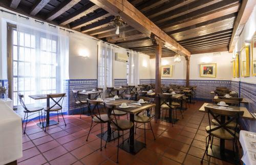 a room with tables and chairs in a restaurant at Palacio de Santa Inés in Granada