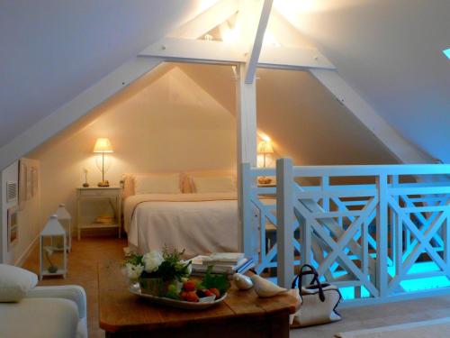 a bedroom with a bed and a table with a bowl of fruit at La Marine de Loire Hôtel & Spa in Montsoreau
