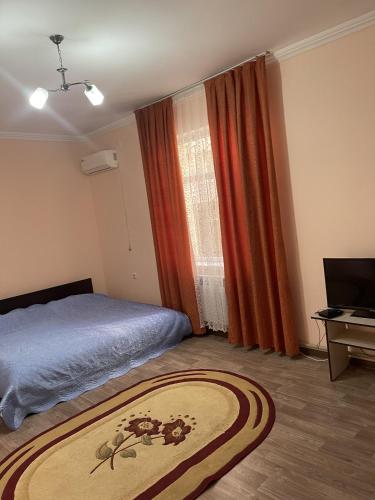 Schlafzimmer mit einem Bett, einem Fenster und einem Teppich in der Unterkunft Mondial apartments in Schymkent