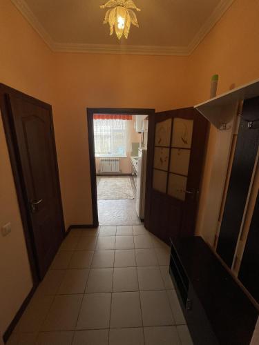 a hallway of a kitchen with a door and a room at Mondial apartments in Shymkent