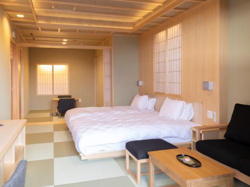 a bedroom with a large bed and a couch at Hotel Shikinoyakata Hakone Ashinoko in Hakone