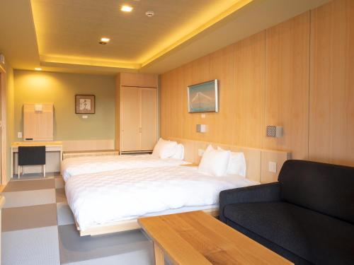 a bedroom with a large bed and a couch at Hotel Shikinoyakata Hakone Ashinoko in Hakone