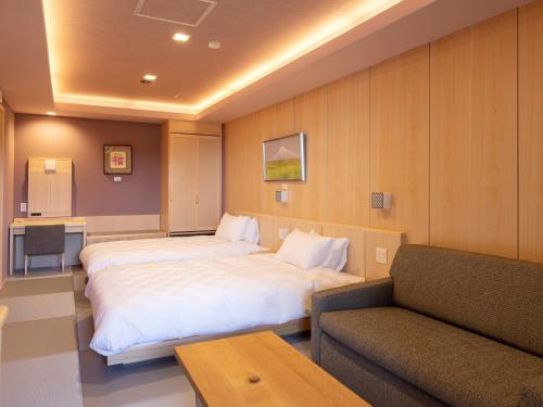 a hotel room with a large bed and a couch at Hotel Shikinoyakata Hakone Ashinoko in Hakone