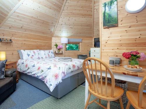 a bedroom with a bed and a desk in a room at Coot Roundhouse - Uk33890 in Cullompton