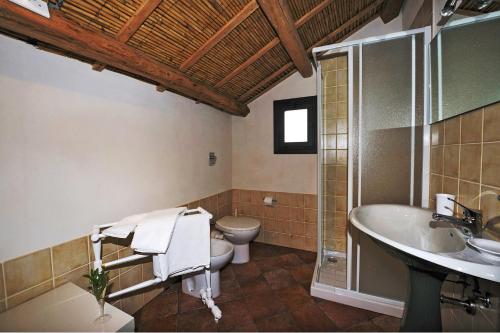 a bathroom with a toilet and a sink and a tub at Casale Laurus in Locogrande