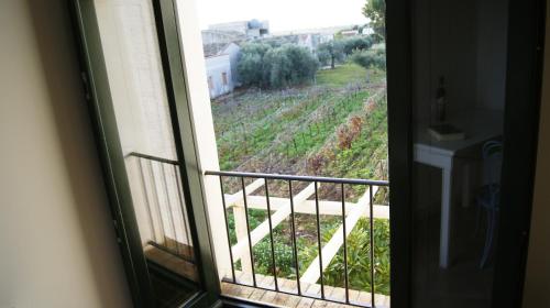 a room with a window looking out at a vineyard at Casale Laurus in Locogrande
